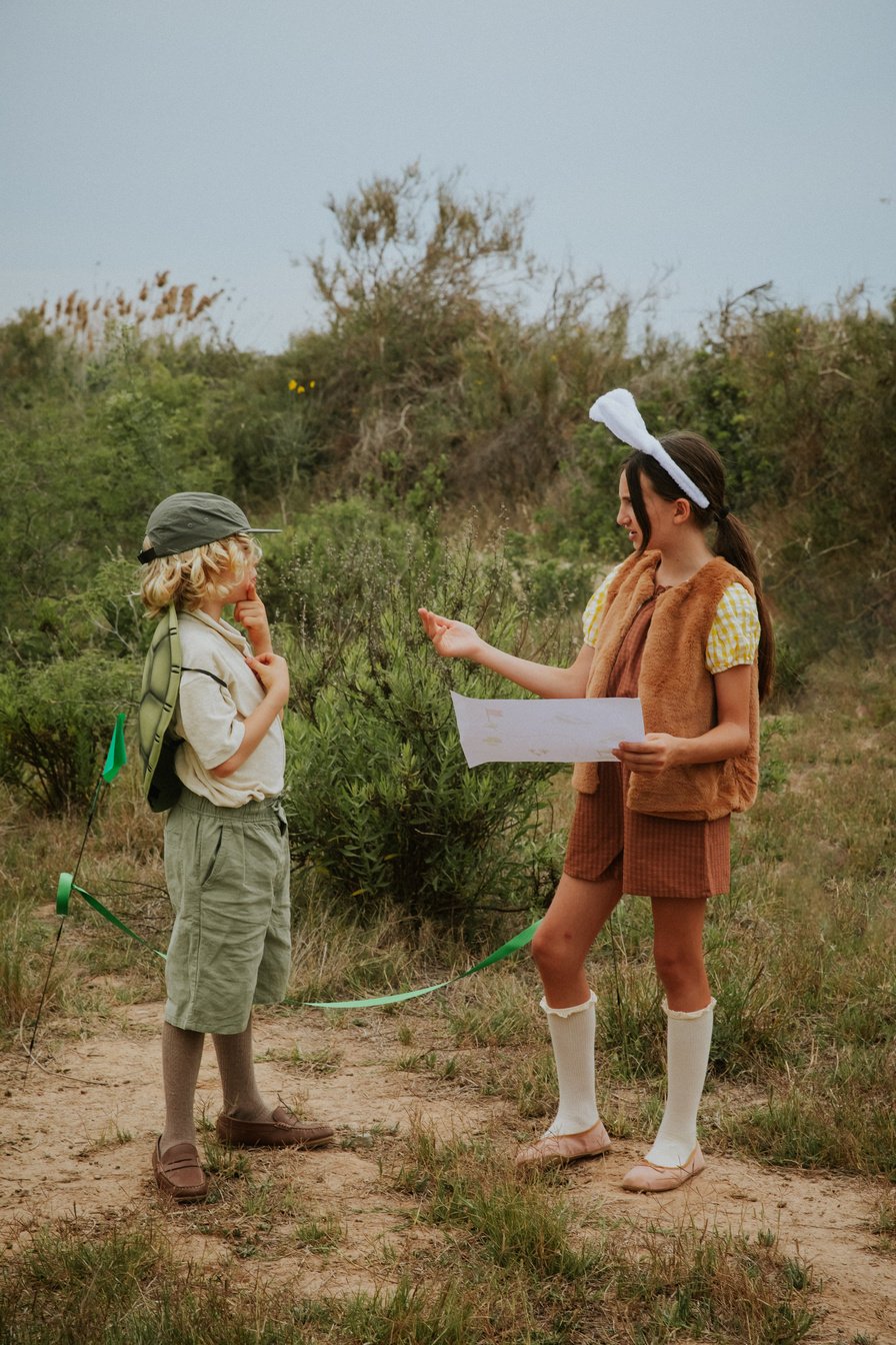 Girl and Boy in Costumes Using Map in the Woods